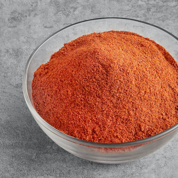 A bowl of McCormick Culinary Ground Red Pepper on a table.