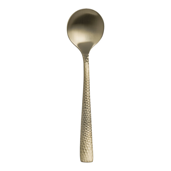 A Varick Malcolm stainless steel bouillon spoon with a gold handle.