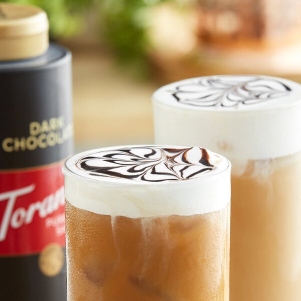 Two glasses of iced coffee, one with Torani dark chocolate flavoring sauce in it.