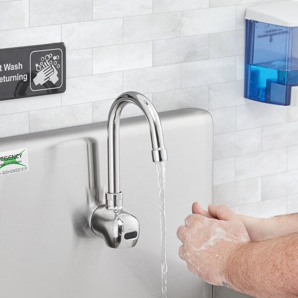 A person washing their hands under a Waterloo hands-free faucet.