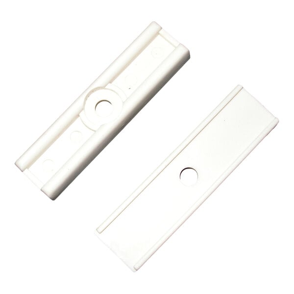 A pair of white plastic door glides with a central hole for mounting.