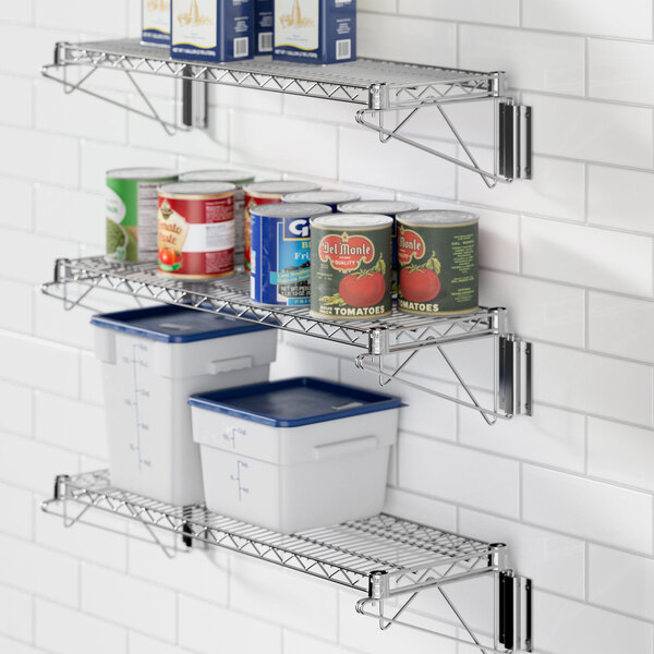 A Regency chrome wall-mount wire shelf with food cans and containers on it.