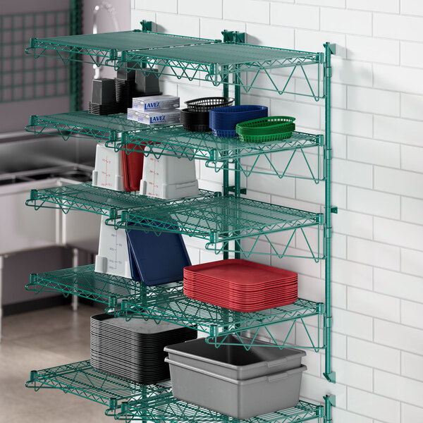 A green metal Regency wire shelving unit with containers on shelves.