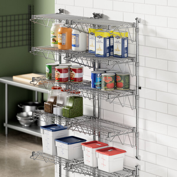 A Regency wall-mount shelf post in a professional kitchen with shelves of food on it.