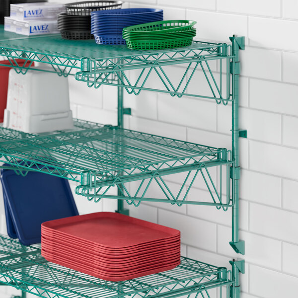 A green metal Regency wire shelf with red plastic trays on it.