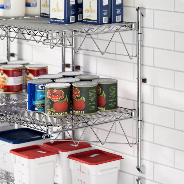 A metal Regency wall-mount shelf with canned food on it.