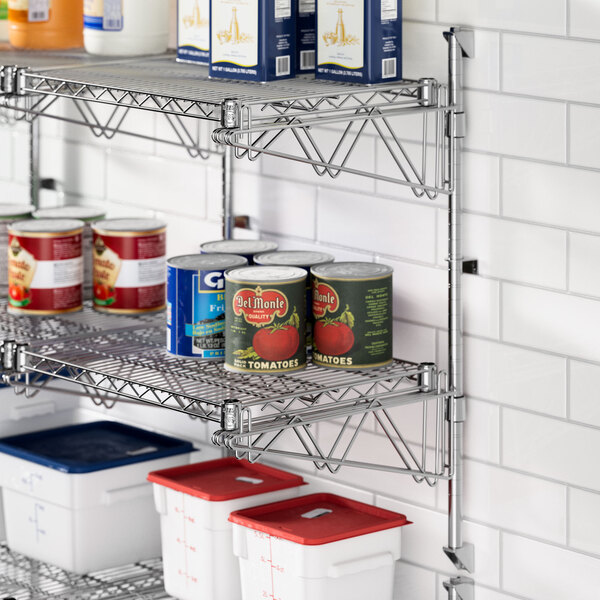 A metal shelf with cans of food on a Regency wall-mount shelf post.