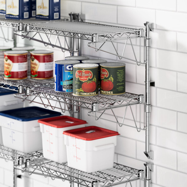 A Regency stainless steel wall-mount shelf with cans and containers on it.