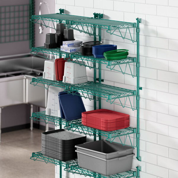 A green metal Regency wall-mount wire shelf with containers on it.