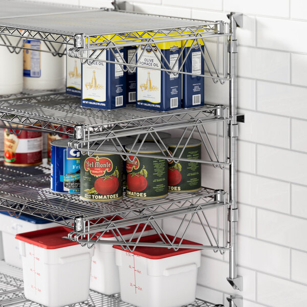 A Regency stainless steel wall-mount shelf with food on it including cans and containers.