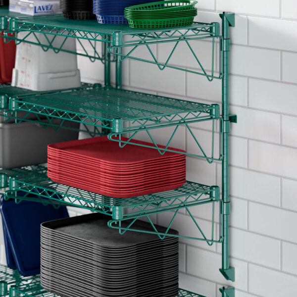 A green Regency wire shelf with dishes on it.