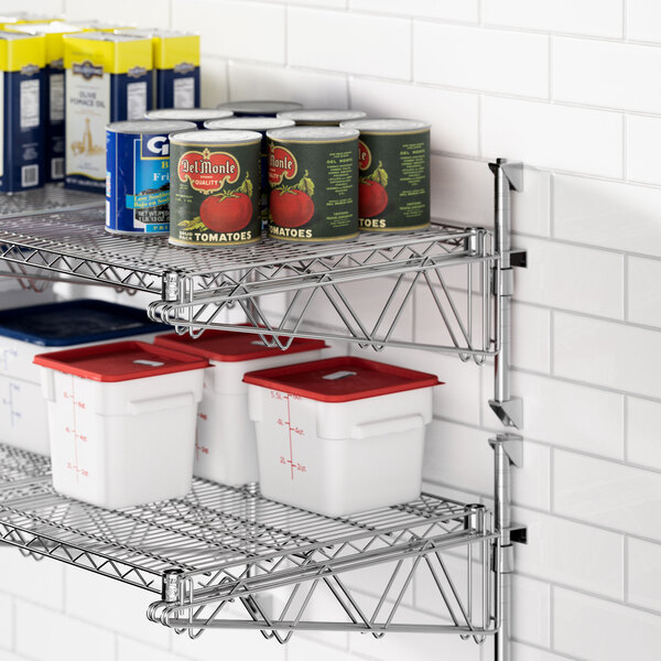 A metal Regency wall-mounted shelf with containers and cans on it.