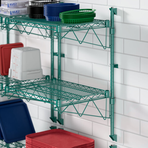 A green Regency wire shelf with dishes and trays on it.