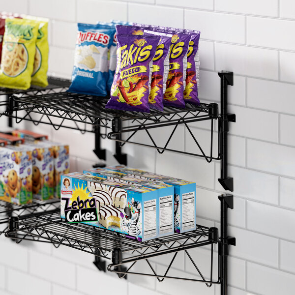 A Regency black wire shelf with snacks on it.