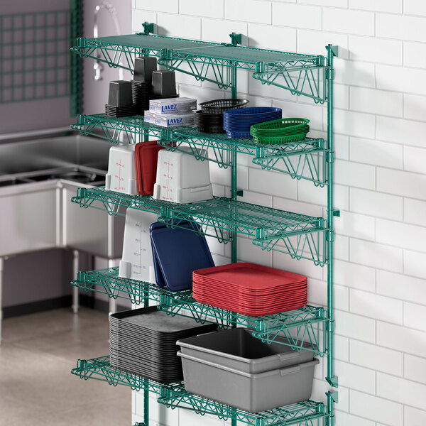 A Regency green wire shelf with different containers and dishes on it.