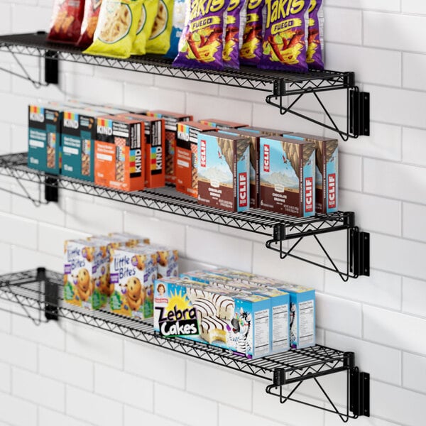 A Regency black wire shelf with food and snacks on it.
