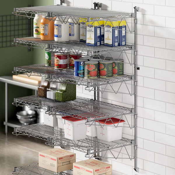 A Regency wall-mount shelf post in a professional kitchen with shelves of food.