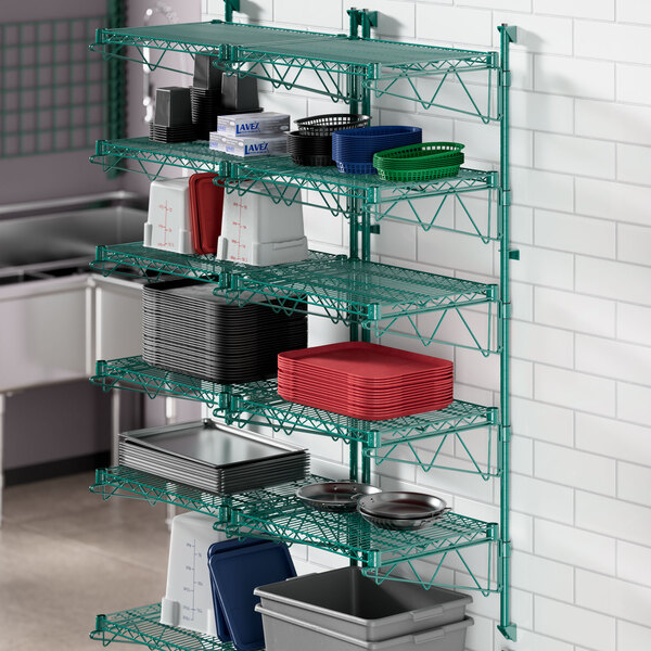 A green metal wire shelving unit with black rectangular and green baskets on it.