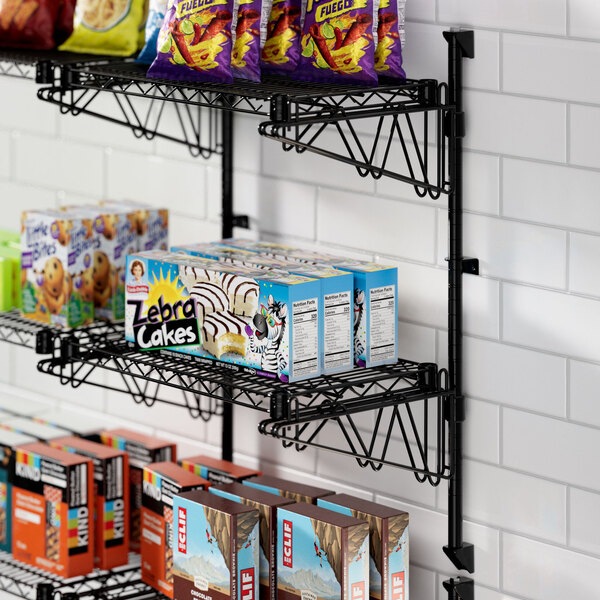 A Regency black wire wall shelf with cake on it.