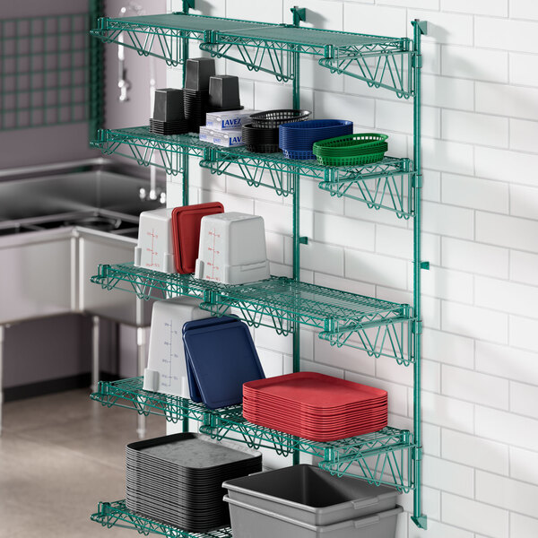 A green metal Regency wall-mount shelf with dishes and containers.