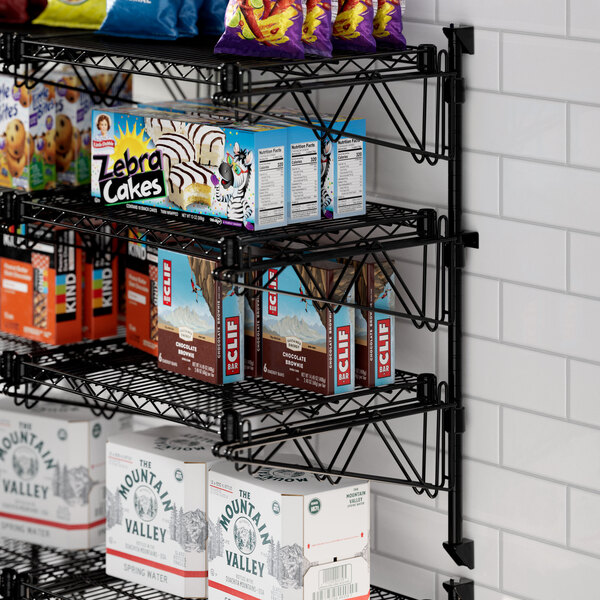 A Regency black wire shelf with snacks on it.