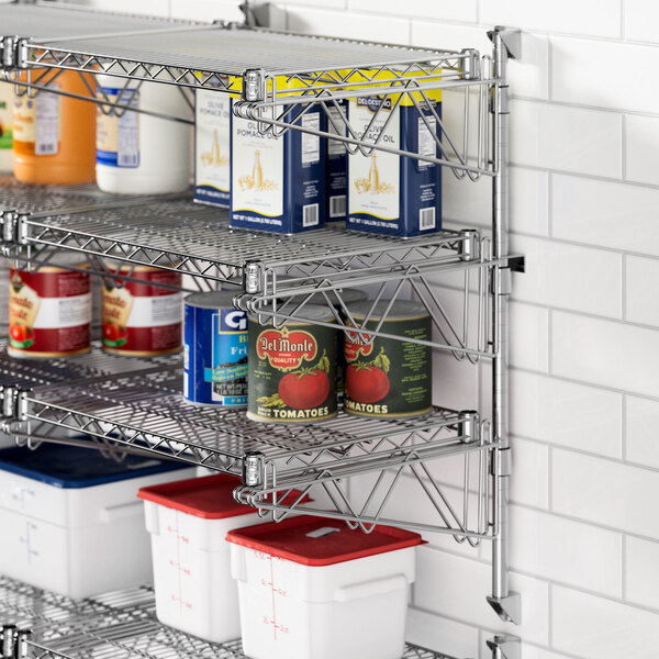 A Regency stainless steel wall-mount shelf with food containers on it.
