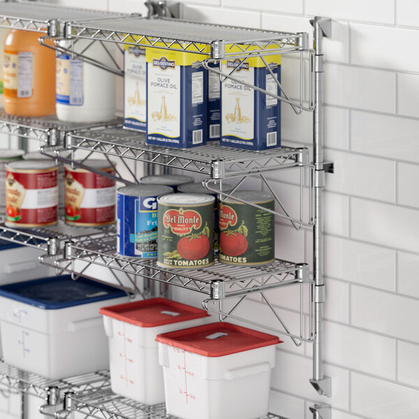 A kitchen wall with a Regency stainless steel wire shelf holding food and containers.