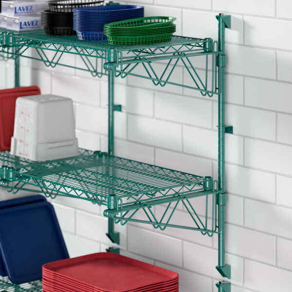 A green Regency wire shelf with white and red trays on it.