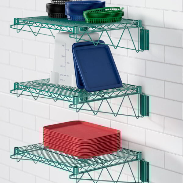 A green Regency wire shelf holding dishes and plates.