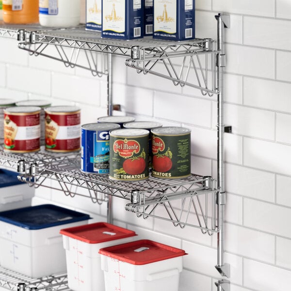 A metal wire shelf with cans of food on it attached to a wall using Regency double brackets.