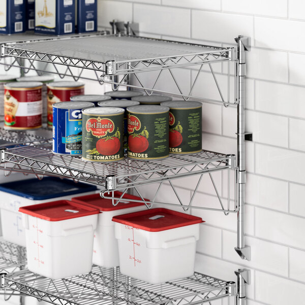 A chrome Regency wall-mount wire shelf with food cans on it.