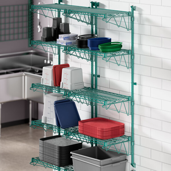 A Regency green wire shelving unit with red and blue containers on a shelf.