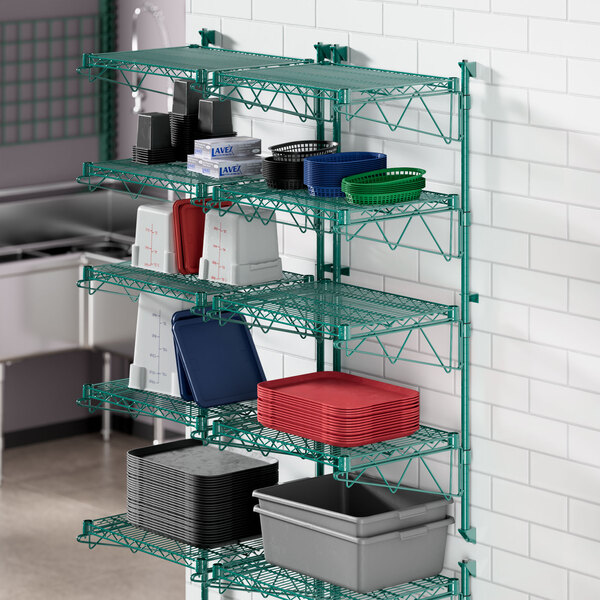 A Regency green wire shelving unit with metal containers on shelves.