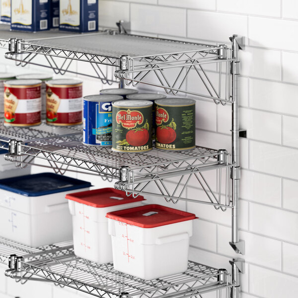 A Regency chrome wall-mount shelf with food containers and cans on a metal shelf.
