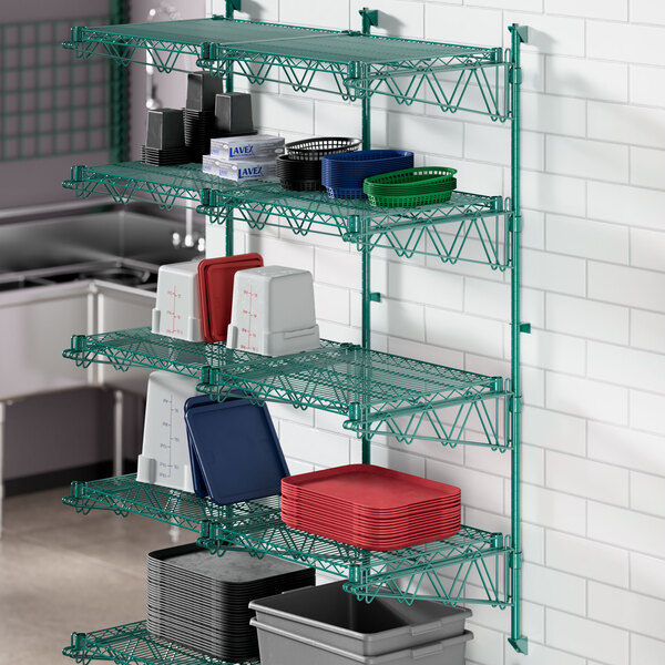 A green metal Regency wall-mount shelf with containers on it.