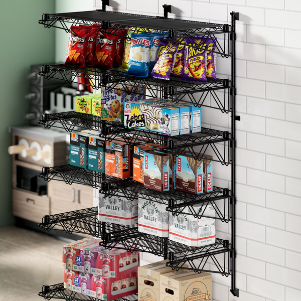 A Regency black metal wire shelf with snacks on it.