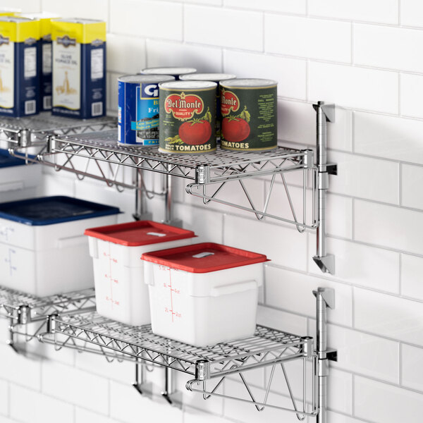 A Regency chrome wall-mounted shelf with food containers and cans on it.