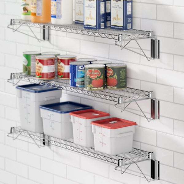 A Regency chrome wire shelf with white and blue food containers and cans on it.