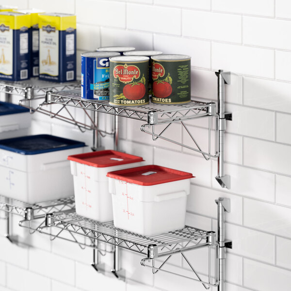 A Regency chrome wall-mounted wire shelf with food containers and cans on it.