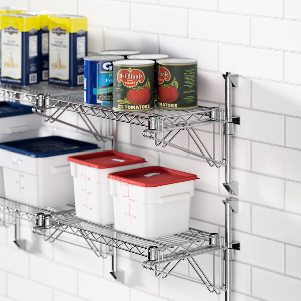 A Regency stainless steel wall-mount shelf with food containers and cans on it.