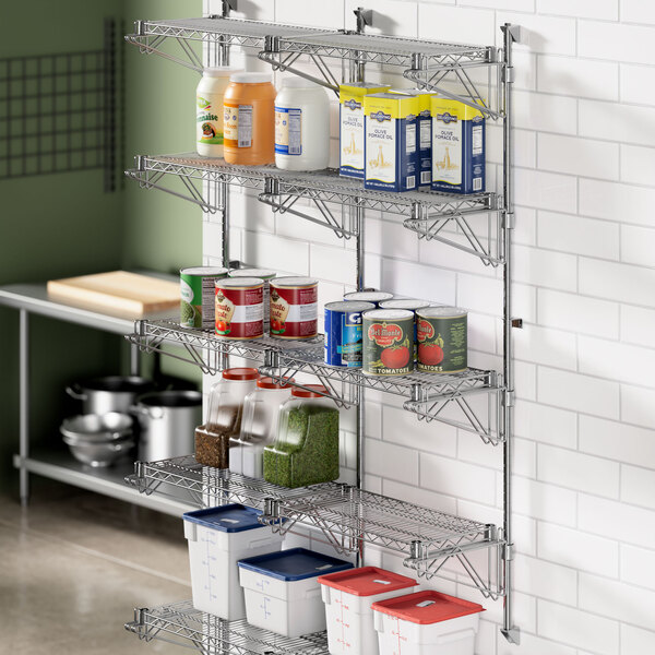 A Regency stainless steel wall-mount shelf with cans on it.