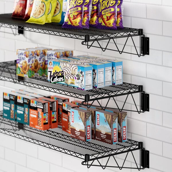 A Regency black wire shelf with food and snacks on it.