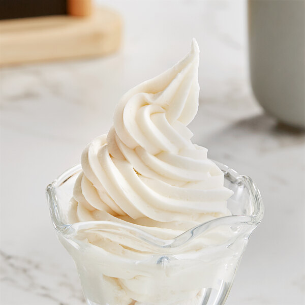 A glass cup with Galliker's vanilla soft serve ice cream with a white swirl.