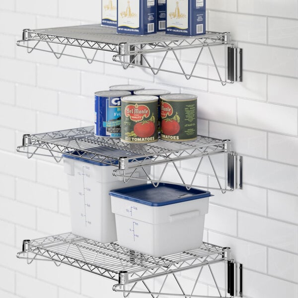 A chrome Regency wall-mount wire shelf with cans on it.