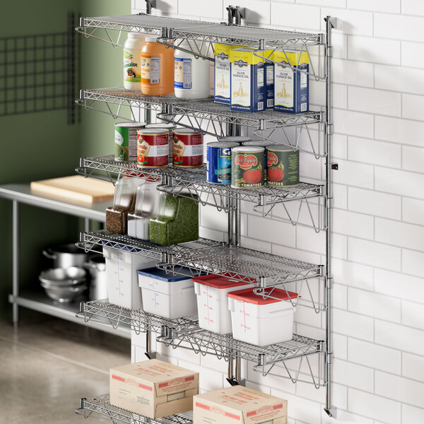 A Regency wall-mount wire shelf post with single brackets holding food containers and cans.