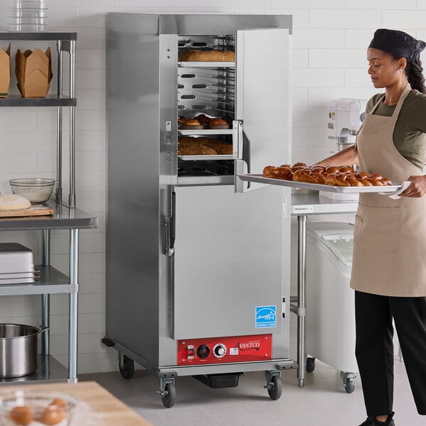 A full size insulated heated holding cabinet with solid stainless steel Dutch doors in a commercial kitchen setting.