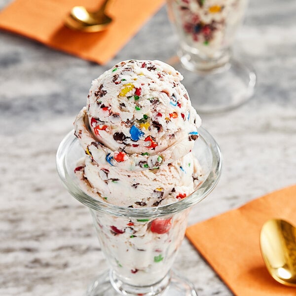 A scoop of ice cream with M&M'S Milk Chocolate candies on top.