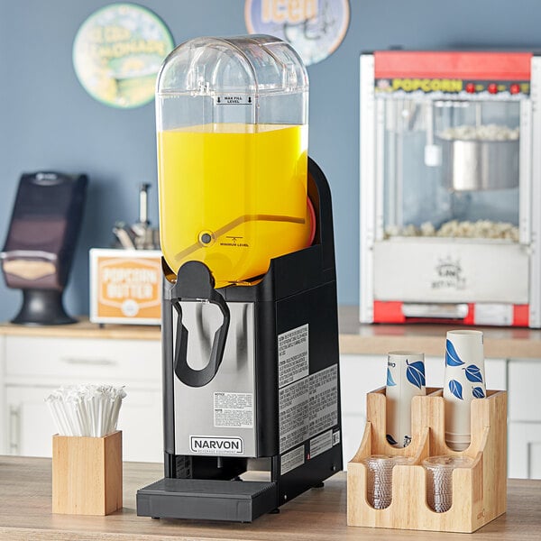 A Narvon refrigerated beverage dispenser with yellow liquid in it.