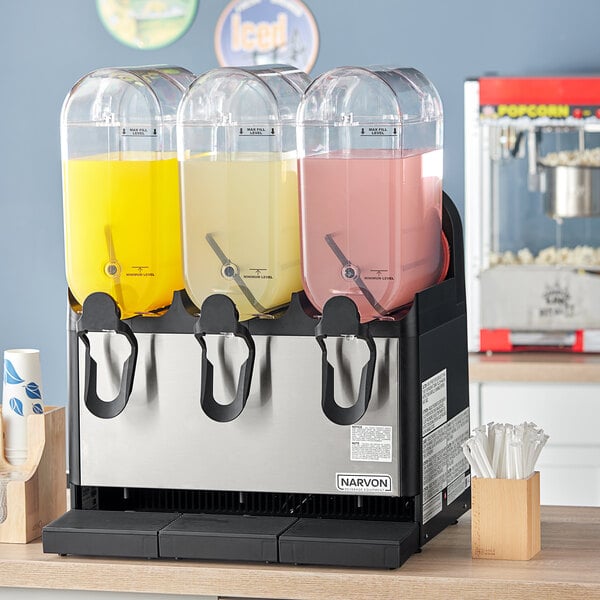 A Narvon refrigerated beverage dispenser with three different colored drinks in it.