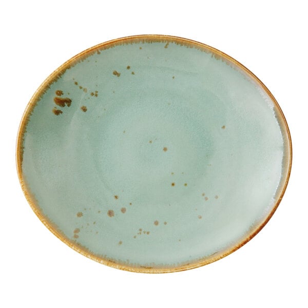 A close up of an Erthe by Fortessa Celadon oval platter with brown speckles on a white background.